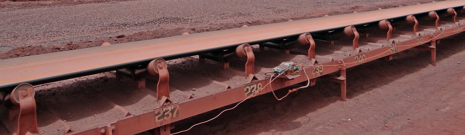 Loaded troughing idler sets on numbered frames along a conveyor